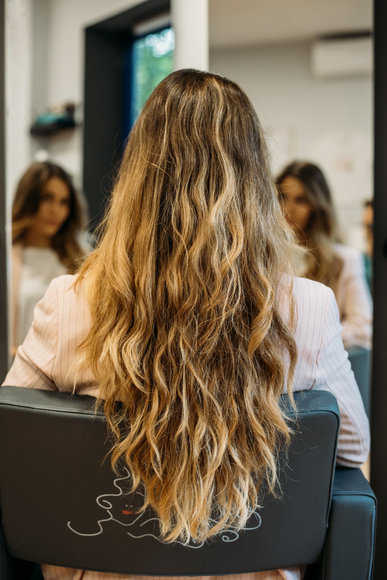 Woman with long hair sitting in a hairdresser